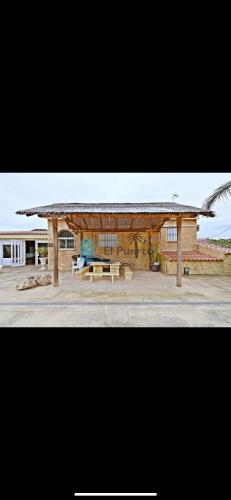 a pavilion with a picnic table and a building at Complejo rural los llanos in Mazarrón