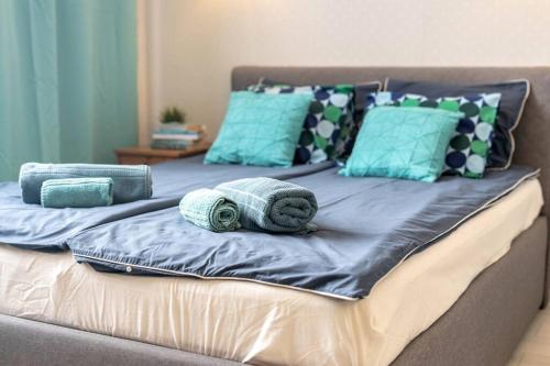 a bed with blue pillows and towels on it at Bella Warszawa Stylish Studio in the CityCenter in Warsaw