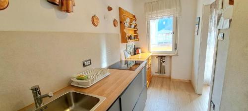 cocina con fregadero y encimera en DolomiApartments - Casa Daria, en Predazzo