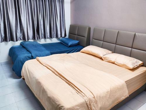 1 dormitorio con 2 camas y sábanas azules en Gaya Homestay 3Bed 2Bath 12pax Taman Gaya JB 5min to Aeon&Ikea 高雅民宿, en Ulu Tiram