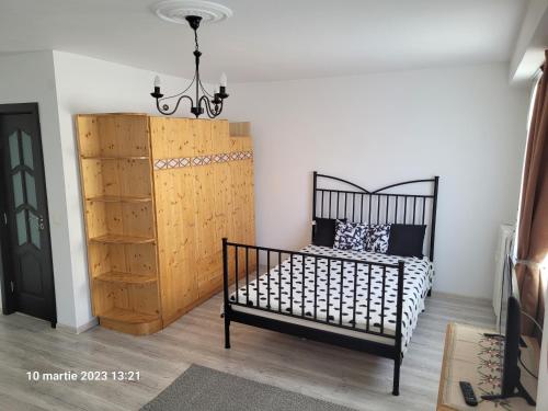 a bedroom with a bed and a chandelier at Neptun Victoriei Central Studio Ploiești in Ploieşti