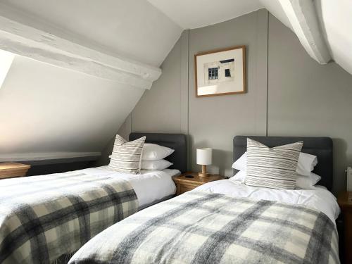 dos camas sentadas una al lado de la otra en un dormitorio en Number 22, Castle Street, en Hay-on-Wye