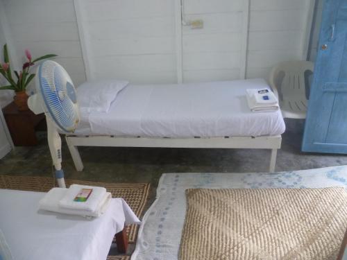 a small room with a bed and a fan at Cabaña El Bien Germina Ya in El Valle