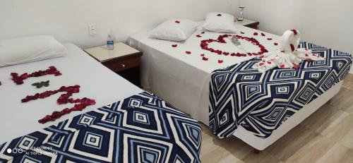 two beds in a room with decorated beds at Pousada Recanto da Paz in Lindóia