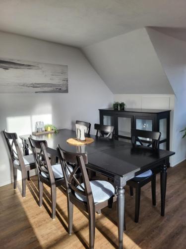 une salle à manger avec une table et des chaises noires dans l'établissement TKS-HOME, à Mündersbach