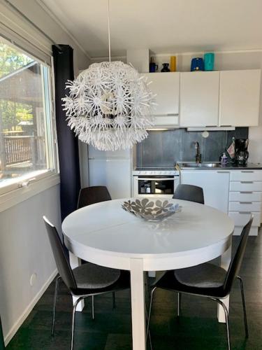 tavolo da pranzo bianco con sedie e lampadario pendente di Havsläge a Oskarshamn