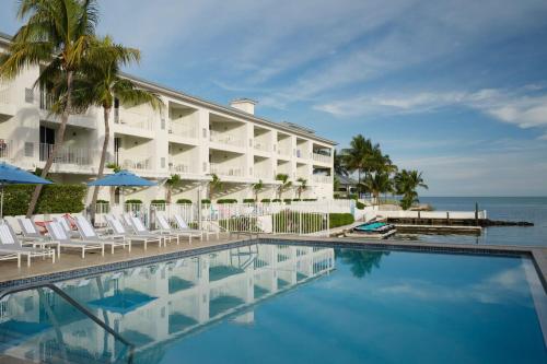 a hotel with a swimming pool in front of a building at Courtyard by Marriott Faro Blanco Resort in Marathon