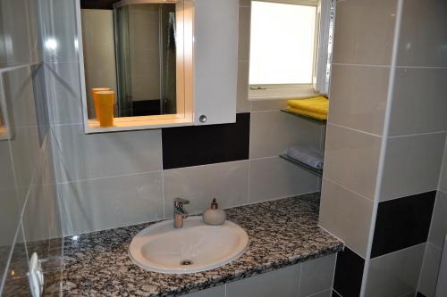 baño con lavabo, espejo y ventana en Villa Adria, en Brist