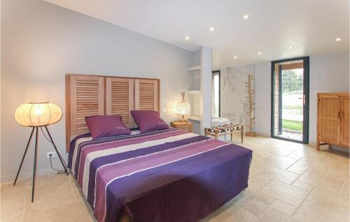 a large bedroom with a large bed with purple sheets at Beautiful Home In Rognonas With Outdoor Swimming Pool in Rognonas