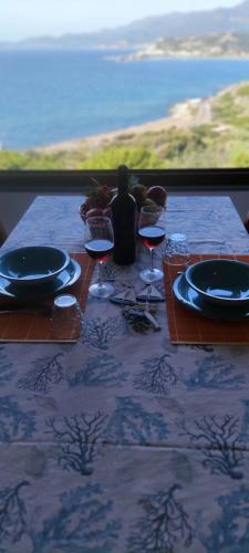 a table with glasses of wine and a view of the ocean at Zafiro House in Magomadas