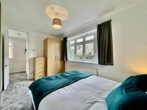齊格威爾的住宿－Modern 3 Bed Chigwell House (Free Parking)，一间卧室设有一张大床和一个窗户。