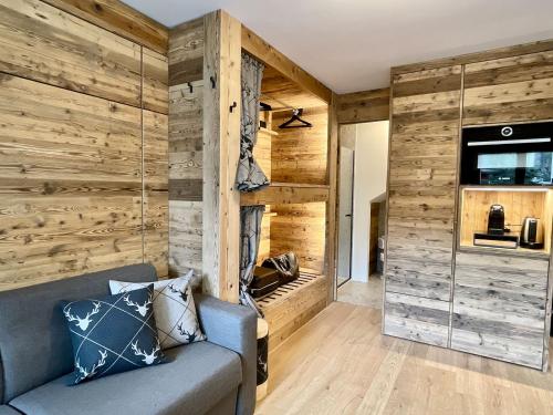 馬代西莫的住宿－Il Ruscello Mountain Apartment，客厅设有木墙和沙发