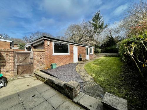 a brick house with a gate and a yard at Stylish 3 Bed Chigwell Home with Free Parking in Chigwell