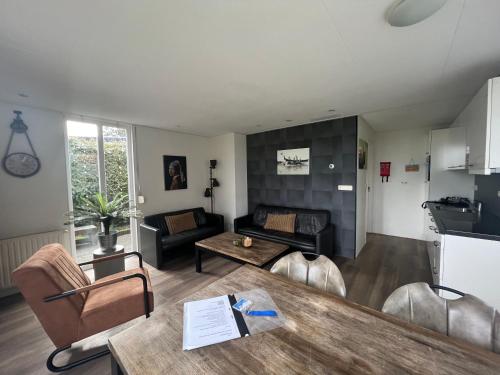 a living room with a table and a couch at Vakantiehuis Tjeukemeer, de Friese Meren in Rohel