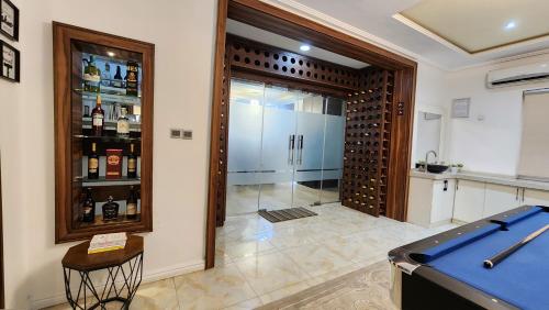 a wine cellar with a sliding glass door with a refrigerator at Captain's Residence in Abuja