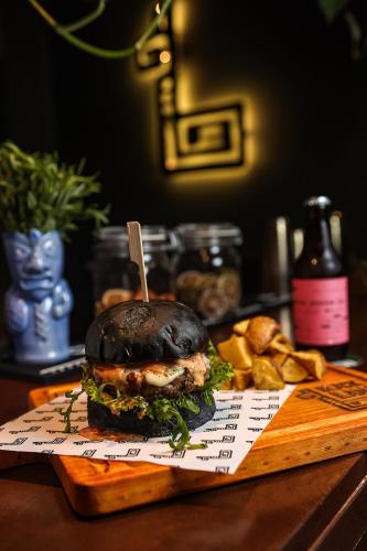 a sandwich on a cutting board on a table with bread at Black Llama Hostel Miraflores in Lima