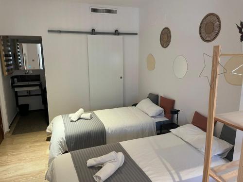 una habitación con 2 camas y una mesa con toallas en Pensión Les Eres, en Puebla de Vallbona