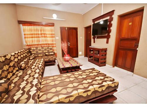 a living room with a couch and a flat screen tv at Amy's Hotel in Lomé