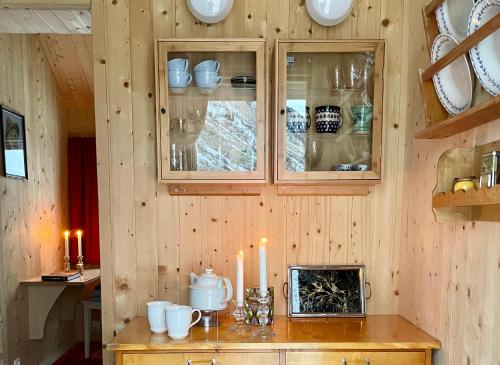 a kitchen with wooden walls and a counter with candles at Villa Lofoten - Edvardbua in Kvalnes