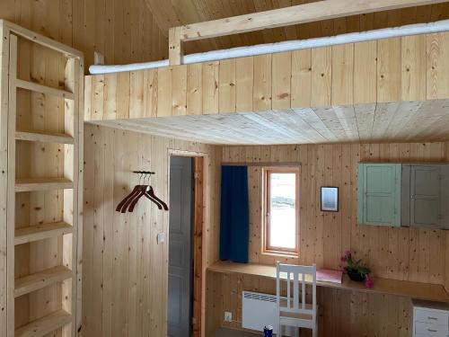a room with wooden walls and a bunk bed at Villa Lofoten - Edvardbua in Kvalnes