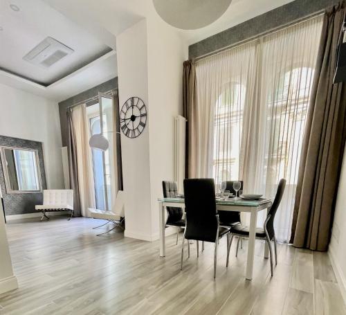una sala da pranzo con tavolo e sedie di Duomo Platinum Apartments a Napoli