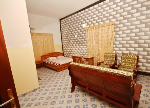 a room with chairs and a bed in a room at Amy's Hotel in Lomé
