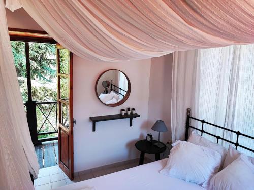 1 dormitorio con cama con espejo y ventana en Liakoto, en Panayia