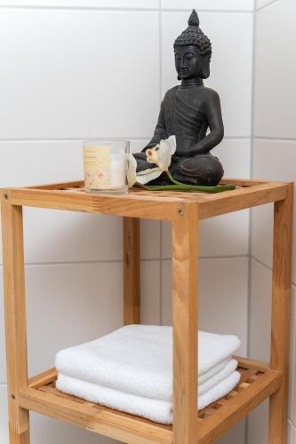 a black statue sitting on a wooden shelf in a bathroom at Fewo Art City-Studio Kassel 1, modern, voll ausgestattet, zentrale Innenstadtlage, ruhiges Schlafzimmer, Balkon in Kassel