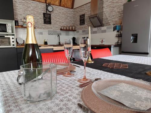 - une bouteille de champagne et deux verres sur une table dans l'établissement Le Cosy Occitan villa chaleureuse indépendante baignoire terrasse jardin, à Carcassonne
