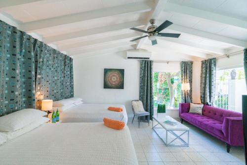 a living room with a bed and a purple couch at BelleVue Oasis - Adults Only in Palm Springs