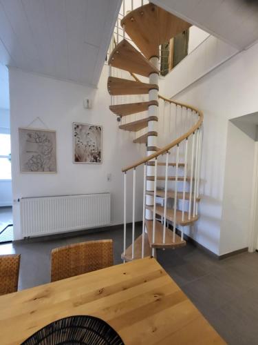 a spiral staircase in a room with a table and chairs at TKS-HOME Am Weiherplatz in Norken
