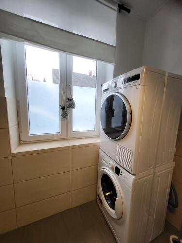 a washer and dryer in a room with a window at TKS-HOME Am Weiherplatz in Norken