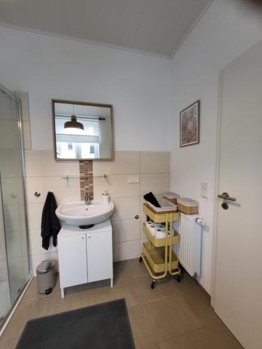 a white bathroom with a sink and a mirror at TKS-HOME Am Weiherplatz 