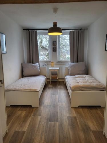 two beds in a room with two windows at TKS-HOME Am Weiherplatz 