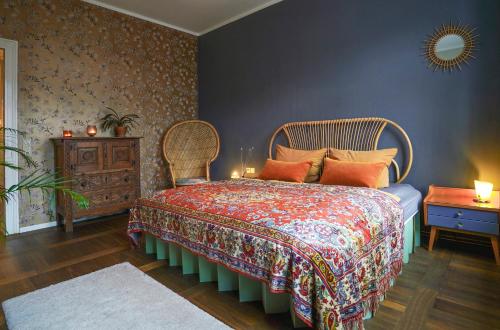 1 dormitorio con 1 cama con colcha colorida en Ferienwohnung Feel Good Apartment - zentrale 65qm Design Fewo im Zittauer Gebirge - bahnhofsnah in ruhiger Lage, en Zittau