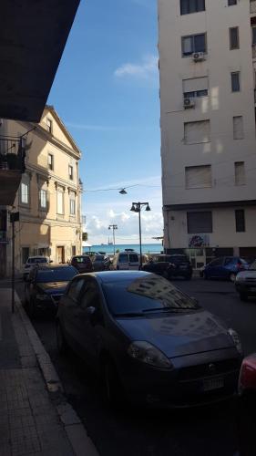 een auto geparkeerd aan de kant van een straat met gebouwen bij Casa Athena in Crotone