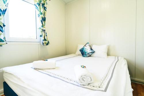 a bedroom with a white bed with two towels on it at Perłowe Wzgórze in Ustronie Morskie