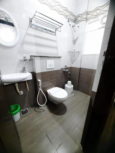 a bathroom with a toilet and a sink at SM Rooms HSR Layout Bengaluru in Bangalore