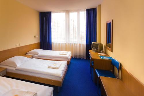 a hotel room with two beds and a television at Dom Turystyczny Indigo in Kraków