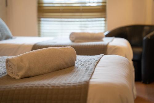 a hotel room with two beds with towels on the couch at Winchelsea Lodge in Winchelsea