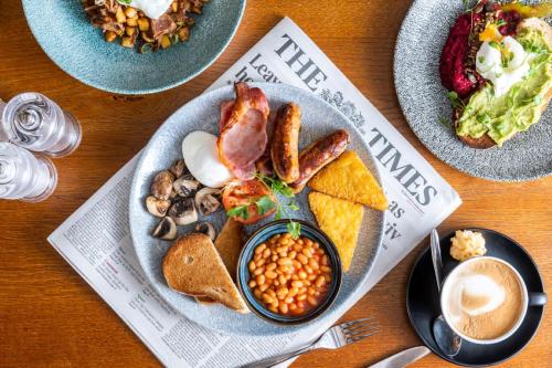 a plate of breakfast food with eggs bacon beans and toast at The Calverley Arms by Innkeeper's Collection in Pudsey