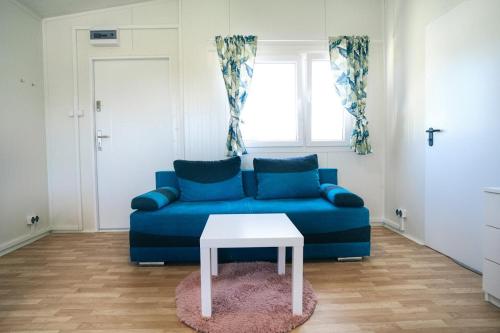 a blue couch with a white table in a living room at Perłowe Wzgórze in Ustronie Morskie
