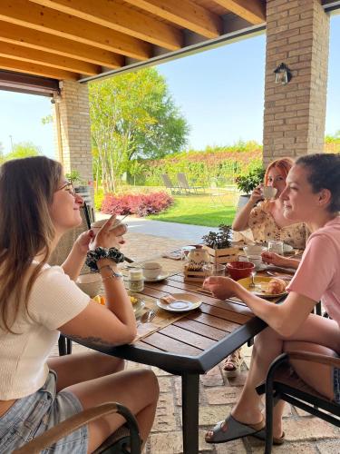 a group of people sitting at a table eating food at Agriturismo Casale ai Prati in Latisana