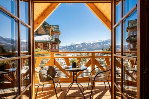 a view from the balcony of a cabin with a table and chairs at Wierchowe Domki z jacuzzi in Kościelisko