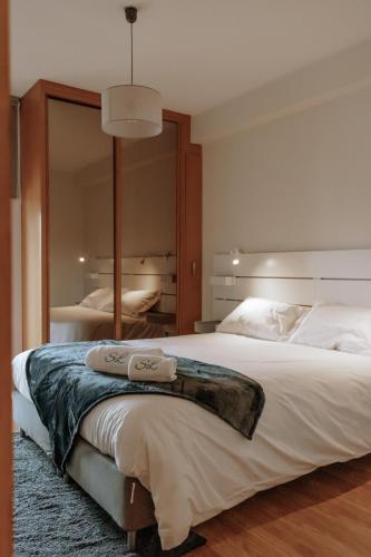 a bedroom with a large bed with a large mirror at Sweet living Porto in Valbom