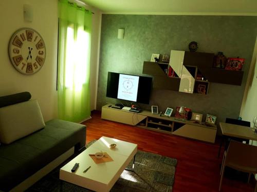 ein Wohnzimmer mit einem Sofa und einem TV in der Unterkunft G&E Bed & Breakfast - Austis in Austis