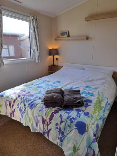 um quarto com uma cama com duas toalhas em Beachside caravan em Mablethorpe