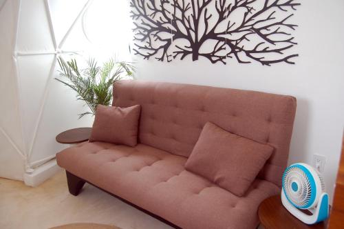 a brown couch with two pillows in a living room at Chiibal in Tulum