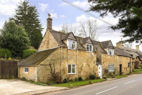 an old stone house on the side of a street at The Farthings Cotswolds Holiday Cottage in Chipping Campden