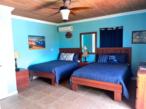 a bedroom with two beds and a ceiling fan at Bay Inn Estates in Alice Town